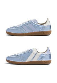 Deux baskets basses bleu clair avec semelles marron, lacets blancs et bandes latérales contrastées blanches et bleu clair, vues de gauche et de droite.