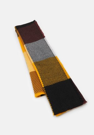 Écharpe pliée avec un motif rayé en noir, jaune, blanc et rouge foncé, avec de petites franges sur un fond blanc.