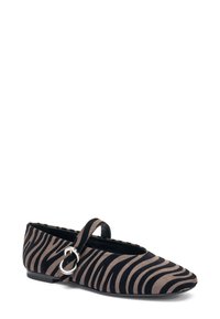 Zapato plano de rayas de cebra en negro y beige con punta redonda, tira y acento de hebilla metálica circular. Hecho de suave material de ante.
