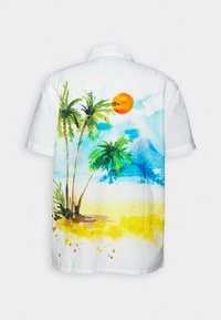 Camisa blanca de manga corta con una colorida escena de playa que incluye palmeras, un sol, montañas y texturas arenosas en estilo acuarela.