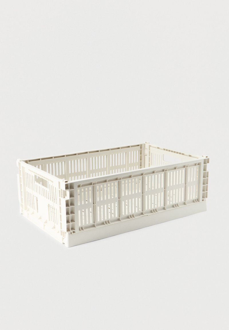 Cajón de almacenamiento rectangular de plástico color blanco hueso con lados ventilados y asas, sobre un fondo blanco liso.