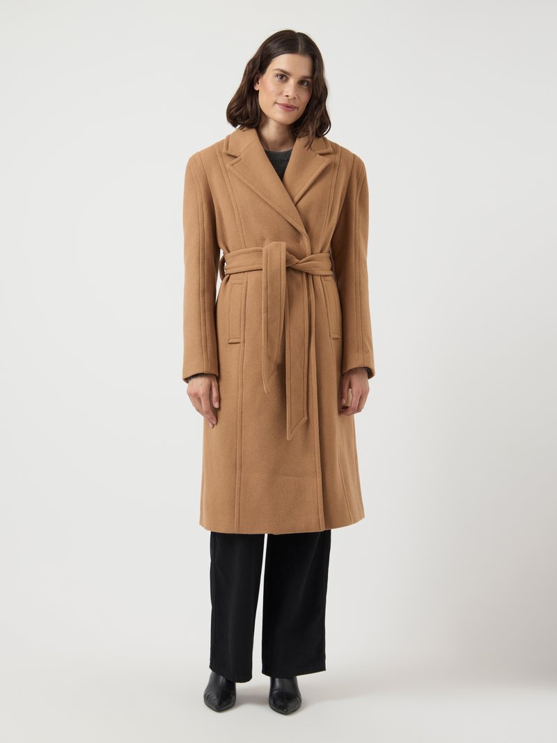 Camel wool blend coat with long sleeves, notch lapels, and a self-tie waist belt. Paired with black wide-leg trousers and pointed black shoes.
