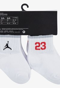 Valged pahkluu sokid ribatud äärisega, millel on must logo ja punane "23" igal sokil. Pakend on must koos tooteinfoga.
