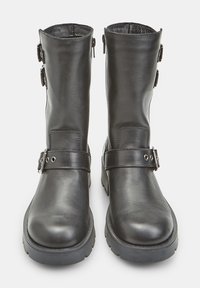 Mustad mustad nahast pahkluu saapad sileda pinnaga, millel on kaks reguleeritavat rihma ja hõbedased sisekujunduselemendid. Tugevad kummist tallad.