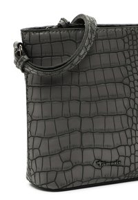 Czarna torebka z tłoczeniem w krokodylą skórę o uporządkowanym kształcie, wyposażona w jeden uchwyt i metaliczne logo z przodu.