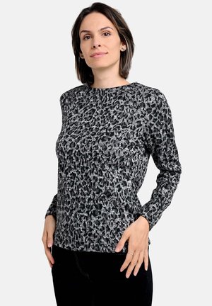 Langärmliges Oberteil mit einem Schwarz-Weiß-Leopardenmuster, das einen runden Ausschnitt und strukturiertes Material aufweist.