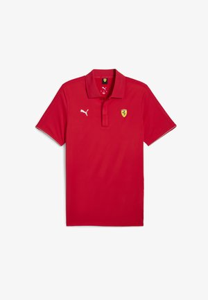 Polo shirt rosso realizzato in tessuto morbido con colletto, maniche corte, logo Puma ed emblema Ferrari sul lato sinistro del petto.