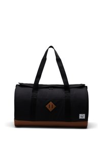 Sort duffelbag med en tan bund, stofkrop, diamantformet læderlap og to top hændler til bæreevne. Har et fold-over design.