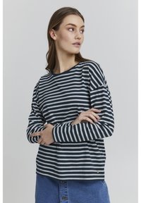 Pika-sleeve, ümmarguse kaelusega t-särk mereväe ja valgete triipudega. Pehme puuvillane materjal ja lõdve istuvus, mille hemil on väike logo aktsent.