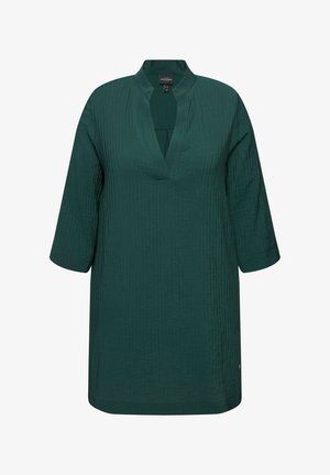 Tunic turchese con scollo a V, maniche a tre quarti, tessuto a coste texture e orlo dritto. Presenta un sottile accento di logo.