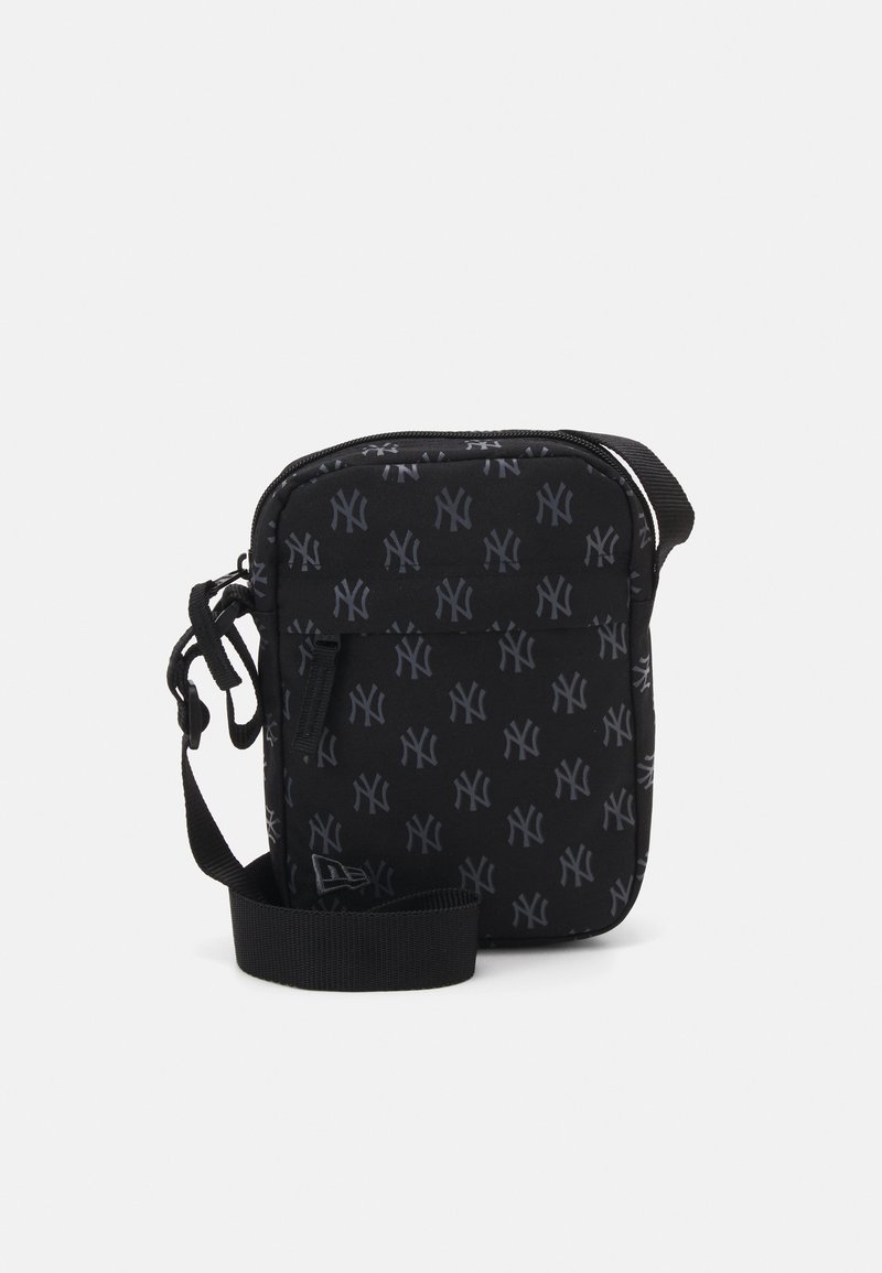 Saco transversal preto com um logótipo NY estampado. Possui fecho com zíper, alça ajustável e tecido texturizado. Forma retangular compacta.