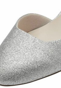 Ballerines en paillettes argentées avec un bout pointu et une découpe basse à l'avant. Doublure intérieure lisse avec une finition mate sur la semelle.