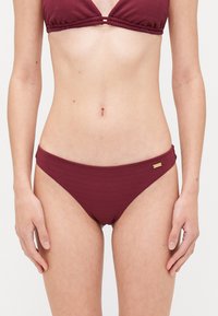 Ribbed two-piece bikini set in deep burgundy. Features a triangle top and low-rise bottom with a gold accent detail on the waistband.