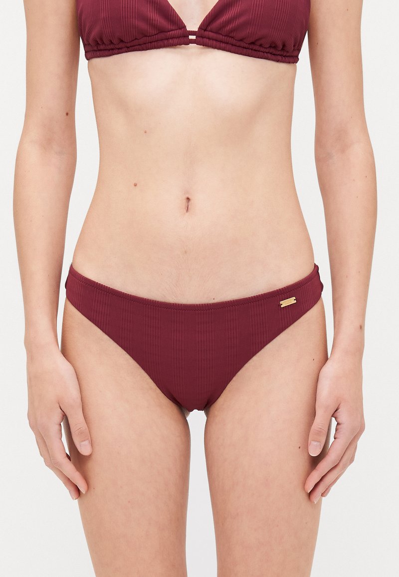 Ribbed two-piece bikini set in deep burgundy. Features a triangle top and low-rise bottom with a gold accent detail on the waistband.