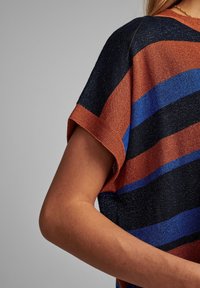 Kortärmad topp i marinblått, orange och blå ränder; strukturerad väv; rundad halsringning; synlig ärmslutdetalj.