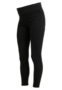 Leggings de maternidad negros hechos de una tela elástica, con una amplia cintura elástica, ajuste ceñido y sin bolsillos visibles.