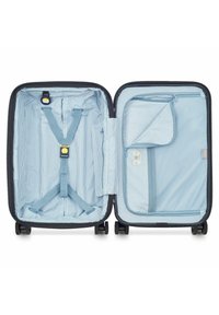 Valise noire avec un intérieur rayé bleu. Ses caractéristiques incluent des sangles ajustables, une poche zippée, et quatre roues pour la mobilité.