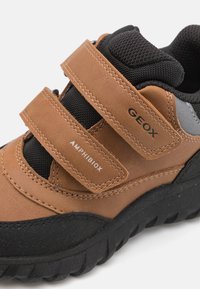 Sneaker Geox Amphibiox brown e nera con doppie fasce in velcro e suola spessa e testurizzata per uso all'aperto.