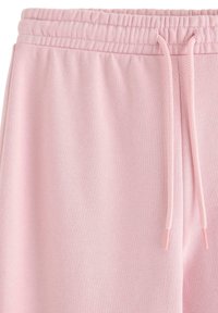 Lichtroze joggingbroek met een elastische tailleband en trekkoord. Zachte textuur met een glad, eenvoudig ontwerp, geschikt voor dagelijks gebruik.