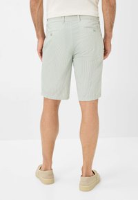 Lichtgroene, gemusterde shorts met een relaxte pasvorm, voorzien van achterzakken en een zachte textuur, gecombineerd met beige instappers.