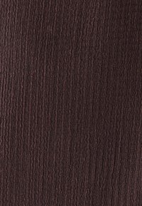 Tissu marron texturé avec un motif ondulé subtil, montrant une teinte riche et foncée avec une finition légèrement rugueuse.