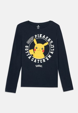 Maglietta nera a maniche lunghe con grafica gialla di Pikachu e testo bianco "PIKACHU GOTTA CATCH 'EM ALL" disposto a cerchio sul davanti.