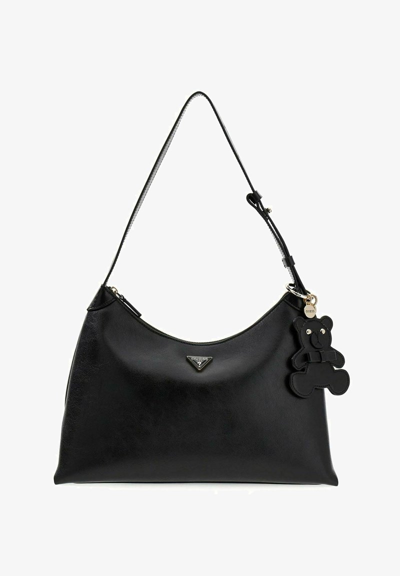 Bolso de hombro Guess de cuero negro con correa ajustable y llavero con oso de peluche negro adjunto.
