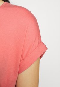 Korallfärgad kortärmad skjorta med rullade ärmar, tillverkad av mjukt tyg, med en subtil struktur och klassisk rund halsringning.