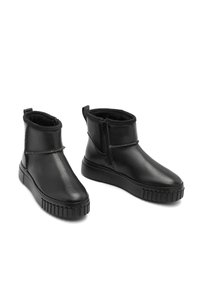 Botines negros con parte superior de cuero liso, cierre con cremallera y suela de goma texturizada. Cuenta con un forro suave y un diseño minimalista.