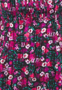 Mustat kankaat mekko, jossa on värikäs kukkakuosi vaaleanpunaisena, valkoisena ja vihreänä. Pleated rakenne ja kerroksellinen muotoilu erikokoisilla kukilla.