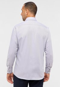 Helllila Hemd aus einem strukturierten Material, mit Button-down-Kragen und langen Ärmeln, die über Knopfmanschetten verfügen. Entspannt geschnitten.