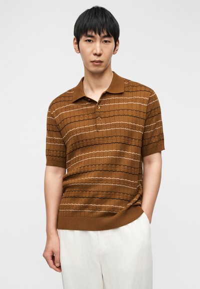 Καφέ κοντομάνικο πόλο με οριζόντιες υφασμάτινες ρίγες, με γιακά, τρεις κουμπότρυπες και ριμπ τελείωμα.