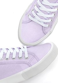 Ljust lila canvas sneakers med vita gummisulor och snören, utrustade med silverfärgade öglor och textilmaterial för grepp och hållbarhet.