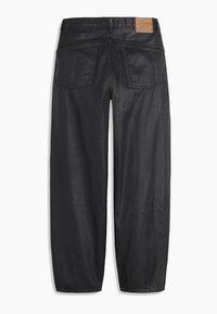 Pantalons larges noirs avec poches arrière et un patch en cuir marron portant la marque sur la taille.
