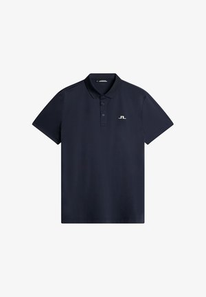 Mörkblå polo skjorta gjord av slät tyg, med krage med två knappar och liten broderad logotyp på vänster bröst. Kort ärm.