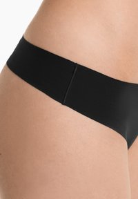 Zwarte ondergoed met een zachte, gladde textuur en een brede tailleband. Beschikt over een naadloos ontwerp voor een minimalistische uitstraling.