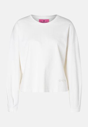Weißes Sweatshirt mit langen Ärmeln und Rundhalsausschnitt mit drei kleinen, umrandeten Herzen, die in der Nähe des unteren Saums auf der linken Seite gestickt sind.