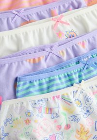 Pile de cinq sous-vêtements colorés pour filles avec des nœuds, présentant des rayures, des fleurs, un soleil souriant et des motifs de griffonnages ludiques.