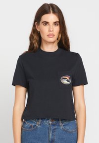 Czarny bawełniany krótki t-shirt z krótkimi rękawami, z kieszonką naszytą i kolorowym logo na klatce piersiowej.