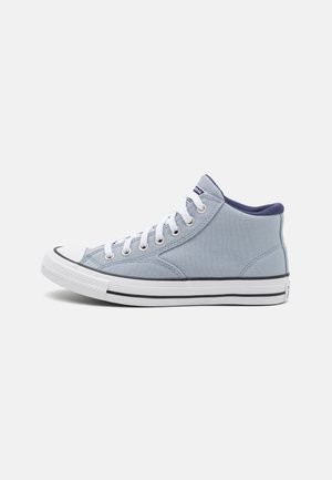 Baskets montantes en toile bleu clair avec lacets blancs, semelle en caoutchouc blanche et bordure noire, vues de côté sur fond blanc.