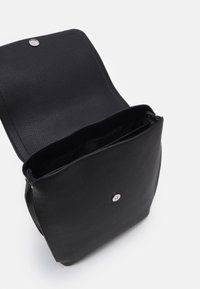 Borsa a tracolla in pelle nera con superficie texturizzata, patta superiore, chiusura a scatto argentata e interno aperto che mostra una fodera liscia.