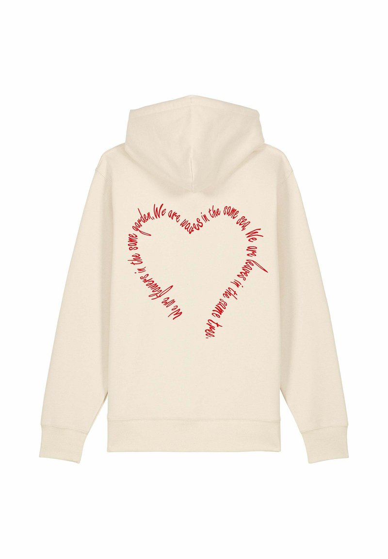Haut à capuche couleur crème avec du texte rouge en forme de cœur au dos, en matière coton douce et au design décontracté.