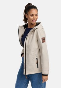 Beige waterproof jacket with a hood, zippered front, and black accents. Features a logo patch on the sleeve and side pockets.