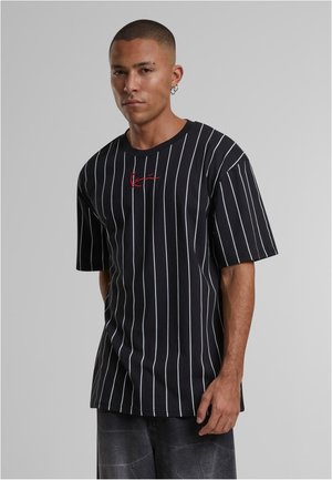 Zwarte T-shirt met korte mouwen, voorzien van witte verticale strepen en rode geborduurde letters op de borst. Gemaakt van een gladde, lichte stof.