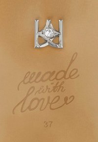 Ciondolo d'argento con un intricato design a stella e una pietra preziosa trasparente centrale su uno sfondo marrone chiaro con il testo "fatto con amore" e "37."
