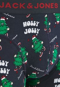 Boxer-briefs bleu marine avec un imprimé de sapins de Noël, des accents rouges et le texte "HOLLY JOLLY", avec une taille noire portant l'étiquette "JACK & JONES".