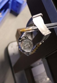 Edelstahlarmbanduhr mit einem zweifarbigen Armband. Die Rückseite zeigt eingravierte Details und den Markennamen "Regal" deutlich.