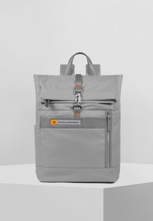 Zaino in nylon grigio con design a roll-top, dotato di tasca frontale con zip, dettagli in pelle e etichetta con logo. Spallacci regolabili.