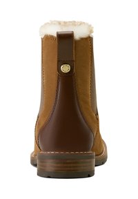 Braunes Lederknöchelboot mit Fellfutter am Schaft, kontrastierendem braunem Absatz und einem runden Logodetail nahe der hinteren Naht.