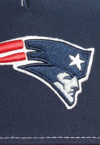 Marineblauer Stoff mit gesticktem Logo der New England Patriots, das das Profil eines Patrioten mit roten und weißen Streifen sowie einem Stern zeigt.